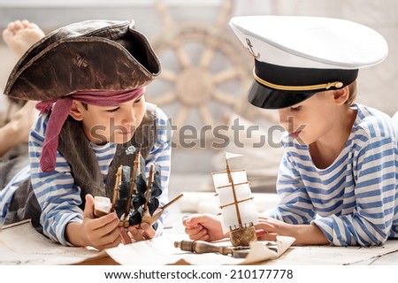 Two boys, a pirate and a sailor, played in a naval battle in his room