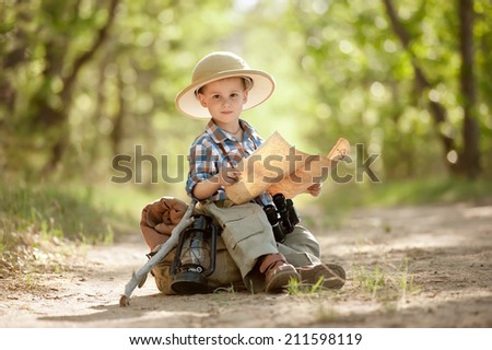 Boy traveler with backpack studying the route map in a sunny summer day