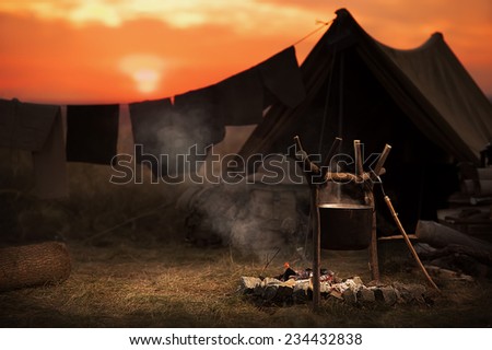 Tent, campfire - tourist destination summer evening on a hilltop at sunset