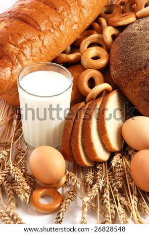 Wheat, bread, milk and eggs on a white background