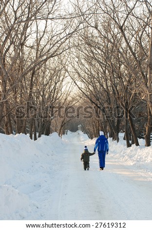 Mum and the son on walk in park in winter day