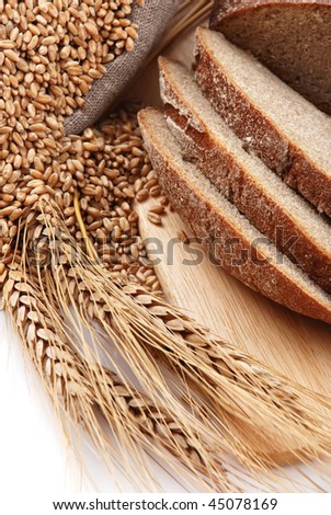 Bread cut on a board, a bag with wheat and ear of the wheat on a white background