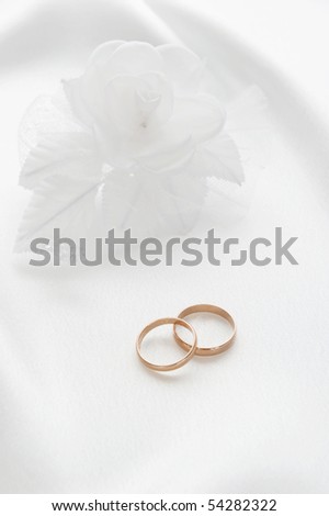 The wedding rings and a bouquet of the bride on a white background