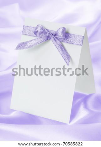 stock photo The wedding invitation with a bow on a violet background