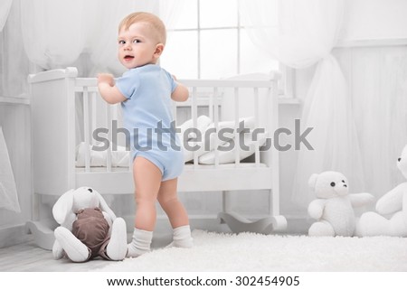 Smiling baby with toys on the carpet in my room