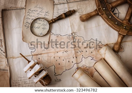 Vintage still-life of old maps, a model of the ship, helm, magnifying glass, old letters on the background of vintage cards