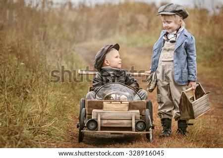 Boy racer on his homemade wooden car with a mechanic. Retouch for retro