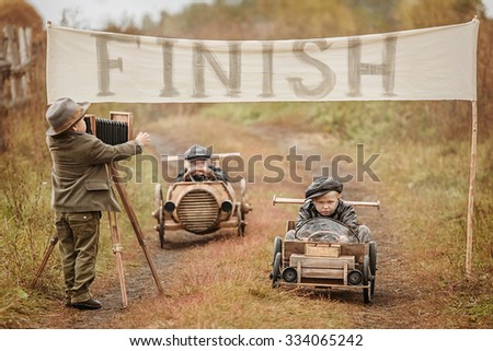 Photographing end of the competition between the two boys racers on homemade wooden car. Retouch for retro