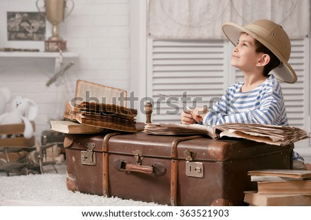 Boy in the image of the traveler fills in the journal of adventure and travel