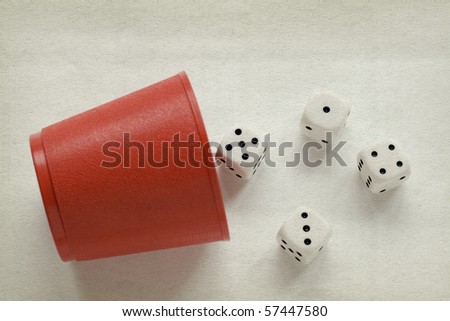 Red dice cup with four dices