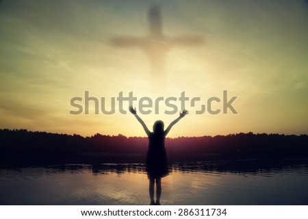 girl standing arms out stretched at sunset
