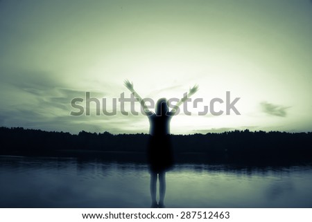 girl standing arms, out stretched at sunset