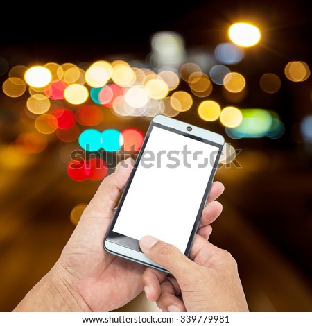 Man asia hand hold and touch screen smart phone on Blurred Defocused Lights of High way Traffic on  Phuket City Road at Night - Commuting and The beauty of the lights at night Concept
