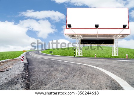Blank billboard for your advertisement  with space for text on road curve,with green grass and blue sky white cloud