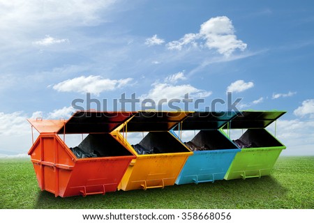 Colorful Industrial Waste Bin (dumpster) for municipal waste or industrial waste on green grass and blue sky background,with ecology concept