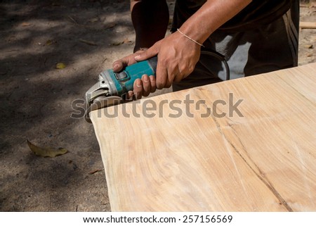 Male hands polishing wooden plank with polishing tools