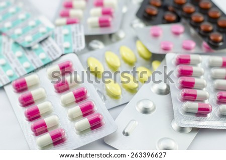 Capsules and pills packed on white background