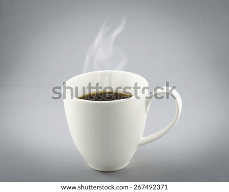 Cup of hot coffee with steam on gray background