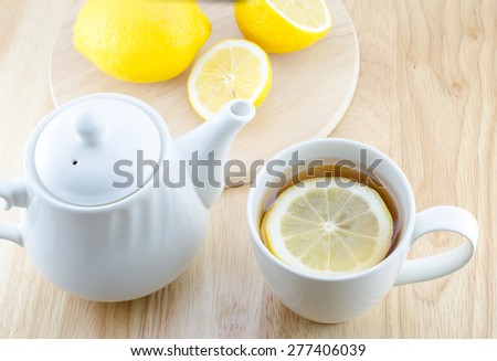 Cup of lemon tea and lemon slice on wooden table