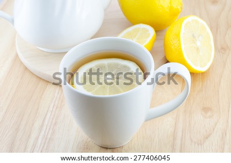 Cup of lemon tea and lemon slice on wooden table
