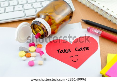 Health Care Concept - Red heart note paper with supplement on computer desk