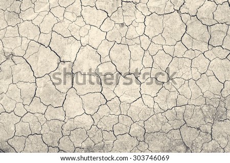 Texture of land dried up by drought, the ground cracks background with vintage tone