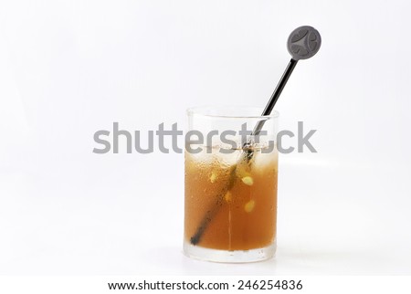 Straight view of a glass of icy cold drinks with stirrer slanting to the right.  Isolated on white background