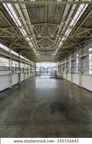 Newly constructed empty warehouse/factory from above during the day, filled with natural light.