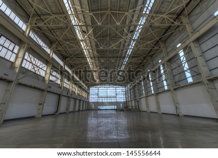 Newly constructed empty warehouse/factory during the day, filled with natural light.