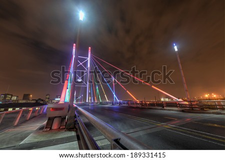 Nelson Mandela Bridge at night. The 284 meter long Nelson Mandela Bridge, officially opened by Nelson Mandela himself, which crosses over the 40 railway lines that lie spread beneath its span.