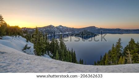 Crater Lake at sunset. It is a caldera lake in south-central Oregon. It is the main feature of Crater Lake National Park and is famous for its deep blue color and water clarity.