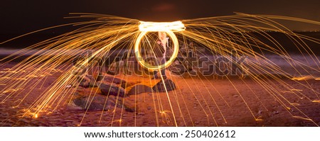 Showers of hot glowing sparks from spinning steel wool at Coney Island Beach, Brooklyn, New York.