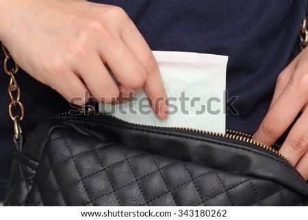 woman hand picking up sanitary napkin from her hand bag