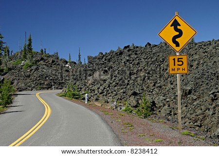 A road winding through lava fields with a 15MPH \