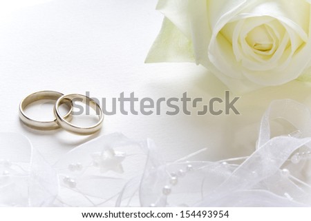 Wedding background with wedding bands and white rose.