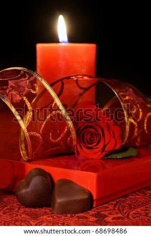 Valentine\'s chocolate hearts, rose and burning candle. Still life.