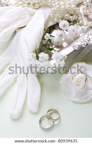 Bridal gloves and vintage accessories with wedding bands. Romantic wedding background, still life.