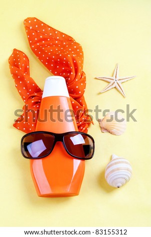 Summer accessories: body balm,  scarf and sunglasses with decorative sea shells.