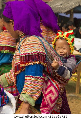 Bac Ha, Vietnam - 17 June 2013 : A flower hmong and her baby at Bac Ha Week end market, North Vietnam.