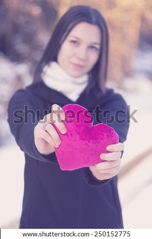 Young girl is holding a pink heart. Outdoor retro-vintage image / My heart for Valentine\'s day / Young girl is holding a pink heart. Outdoor retro-vintage image