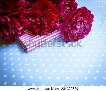 Floral frame with pink peonies on wooden background