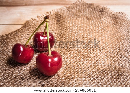 Healthy organic vegetarian super food cherries in clay dish on rustic kitchen table background. Dark photo, rustic style, natural light