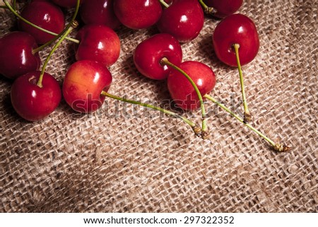 Healthy organic vegetarian super food cherries in clay dish on rustic kitchen table background. Dark photo, rustic style, natural light