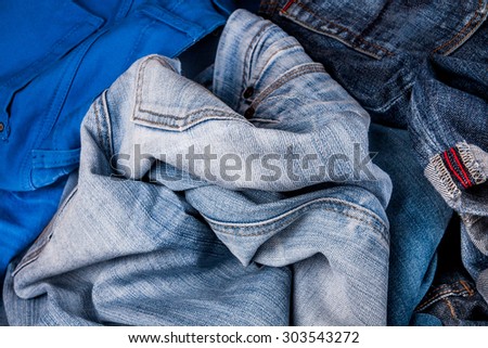 fashionable clothes. pile of jeans on a wooden background