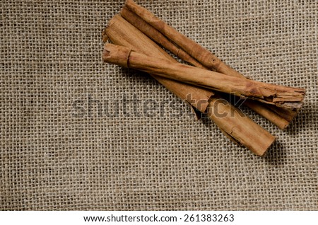 image of cinnamon spice with orange flower on a brown sack background.