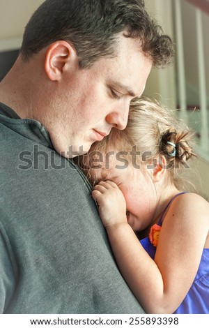 sad father comforting his crying preschool age daughter. Great parenting image