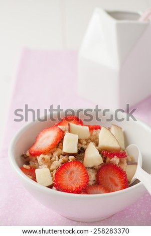a bowl of oatmeal with strawberries, apples and bananas