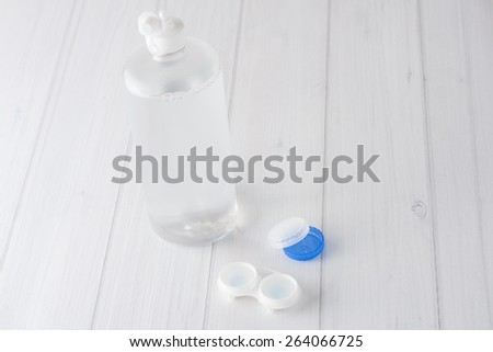 Isolated close up contact lenses case with contacts and solution on white background