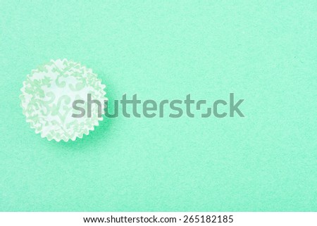 empty patterned cupcake liner on bright textured background, horizontal top view with room for text
