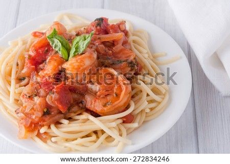 shrimp cooked in wine tomato sauce with fresh basil over spaghetti pasta